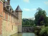 Château de Carrouges - Facade of the château, moat, park and church in the background Carrouges