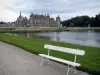 Château de Chantilly - Parc : jardin à la française de Le Nôtre : banc en premier plan, la Manche, pelouses et château