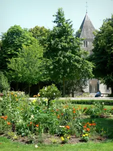 Château-Gontier - Blumenbeet mit Blick auf den Glockenturm der Kirche Saint-Jean-Baptiste umgeben von Bäumen