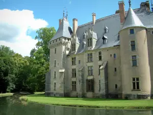 Château de Meillant - Tours du château, arbres et douves, nuages dans le ciel