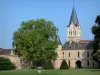 Château de La Palice - Porche d'entrée, pelouses, arbustes taillés, arbres, et clocher de l'église de Lapalisse dominant l'ensemble