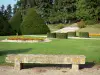 Château de Ravel - Jardin à la française du château : banc en pierre, pelouses, parterres de fleurs et ifs taillés en cône