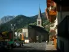 Châtel - Inicio de balcón de madera con flores, la iglesia del pueblo (estación de esquí y en verano), pastos y bosques, en el Chablais