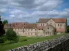 Guide du Cher - Abbaye de Noirlac - Abbaye cistercienne et parc avec des arbres, nuages dans le ciel