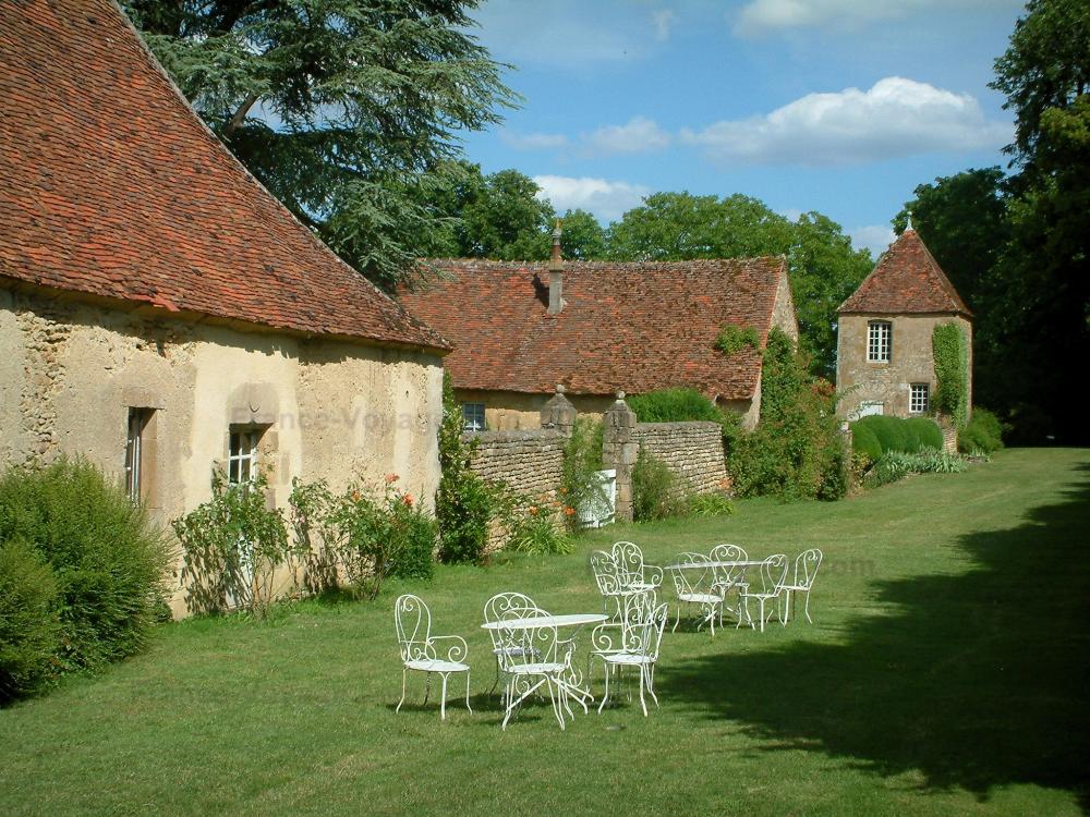 Guide du Cher - Château de Villiers - Bâtiments (communs) du château et jardin avec tables, chaises et arbres