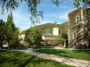 Cidade medieval de Conflans - Ramos de uma árvore em primeiro plano, Sarrazine torre jardim com seus caminhos, gramados, árvores, bancos e flores, Igreja barroca de Saint-Grat e floresta ao fundo