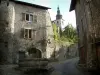 Cité médiévale de Conflans - Rue Gabriel-Pérouse avec fontaine décorée de fleurs, maisons, enseigne en fer forgé et clocher de l'église Saint-Grat