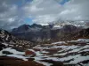 Col de l'Iseran - Parc National de la Vanoise : pelouses alpines parsemées de neige, montagne et nuages dans le ciel (route des Grandes Alpes)