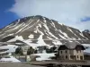 Col du Lautaret - Depuis le col du Lautaret, vue sur maisons et montagne parsemée de neige ; dans le Parc National des Écrins