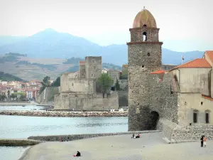 Collioure - Vermilion coast: bell tower of the Notre-Dame-des-Anges church, beach, Mediterranean sea and Royal castle of Collioure