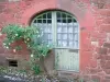 Collonges-la-Rouge - Franse raam van een rode zandsteen stenen huis versierd met een roos in bloei