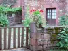 Collonges-la-Rouge - Casa de pedra de arenito vermelho e sua entrada decorada com flores