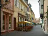 Colmar - Strasse Marchand mit ihren Häusern mit farbigen Fassaden und eine Kaffeeterrasse