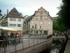 Colmar - Place de l'Ancienne Douane avec fontaine Schwendi, terrasses de restaurants, maisons à colombages et rivière