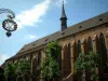 Colmar - Geschäftsschild aus Schmiedeeisen, Bäume und Kirche der Dominikaner