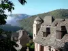 Conques - Tour Kasteel Humières en huizen met leistenen daken van het middeleeuwse dorp, met uitzicht op het groene landschap in de omgeving