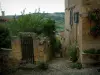 Cordes-sur-Ciel - Portillon d'un jardin et maisons de la cité médiévale avec vue sur les collines environnantes