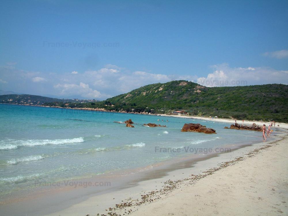 Guide de la Corse-du-Sud - Coti-Chiavari - Plage de sable, rochers, mer méditerranée avec petites vagues, colline tapissée de forêt