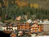 Courchevel - Spruces and trees in autumn, chairlift (ski lift), chalets and residences of the Courchevel 1850 ski resort (winter sports)