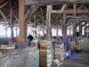 Crémieu - Sous la halle médiévale : charpente en chêne et cageots du marché
