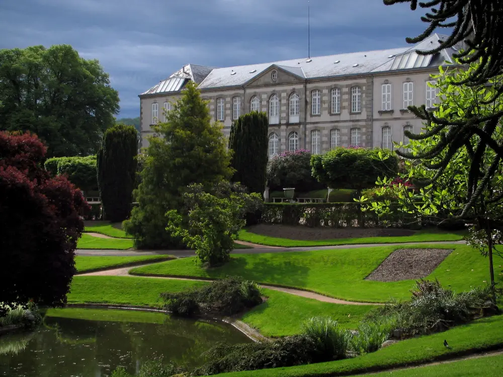 Guia da Creuse - Pousio - Jardim (parque) com bacia de água, gramados, caminhos e árvores, senatorerie hotel que abriga o Museu de Arte e Arqueologia (Museu Senatorerie) e céu tempestuoso