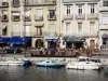 Definir - Edifícios, terraços de café, barcos atracados no cais, canal