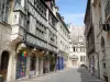 Dijon - Rue bordée de maisons anciennes à pans de bois et hôtel Aubriot avec son toit de tuiles vernissées en arrière-plan