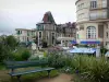 Dinard - Resort aan de Costa Smeralda: bank en bloemen op de voorgrond, villa, appartement gebouwen en winkels