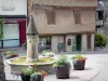 Donzenac - Fontaine entourée de fleurs et maisons à pans de bois