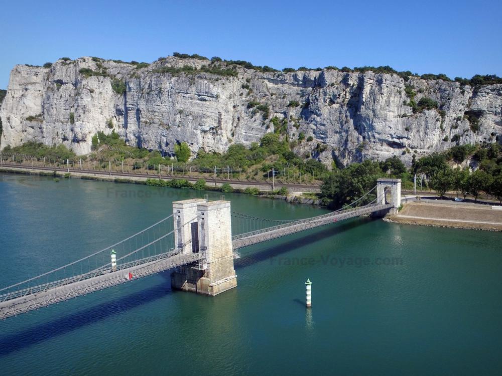 Guide de la Drôme - Défilé de Donzère - Vue sur le pont suspendu du Robinet enjambant le fleuve Rhône et les falaises de calcaire