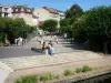 Enghien les Bains - Jardin des Roses com sua fonte e seus caramanchões cobertos de roseiras; fachadas do spa ao fundo