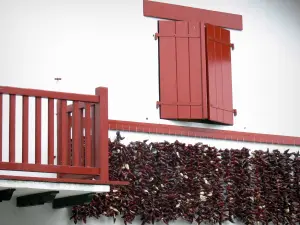 Espelette - Piments séchant sur une façade de maison aux volets rouges