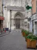 Étampes - Rue pavée agrémentée de bacs à fleurs avec vue sur le portail royal (portail latéral) de la collégiale Notre-Dame-du-Fort
