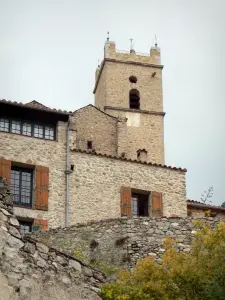 Eus - Bell tower of the Saint-Vincent-d'En-Haut church and facade of a stone house
