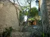 Eze - Casas de pedra da aldeia com árvores, incluindo uma mimosa
