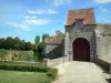 Feudo de Epoisses - La entrada a la masía fortificada medieval, foso, césped y árboles en la ciudad de Bombón