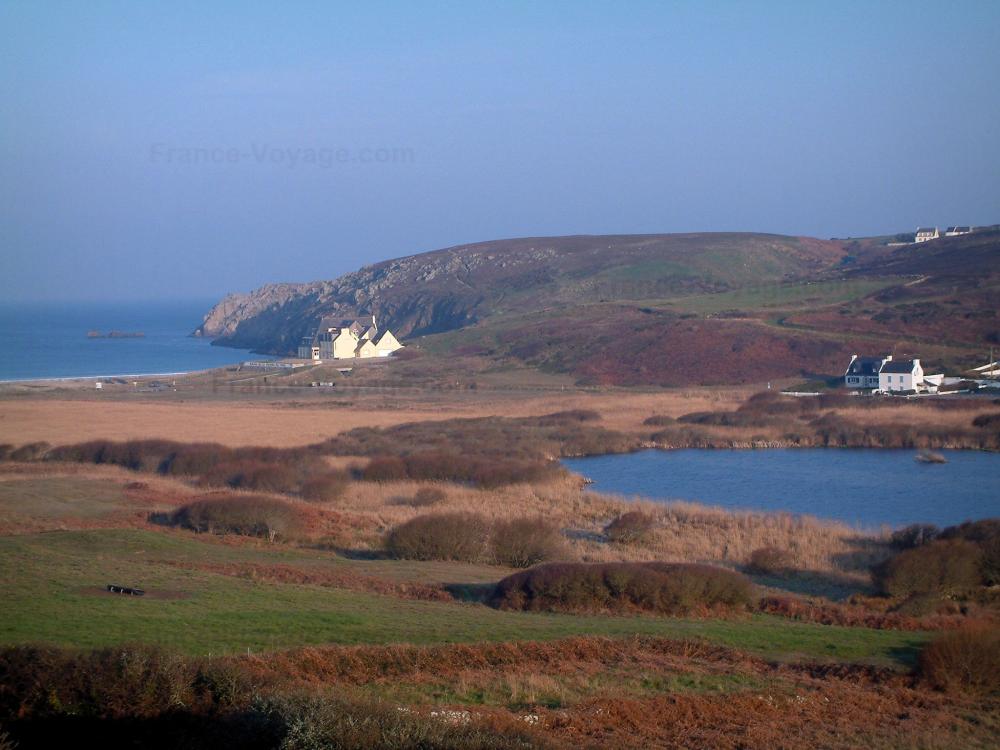 Guide du Finistère - Paysages du littoral de Bretagne - Côte recouverte de champs et d'arbustes, mare, maisons et mer (océan atlantique)