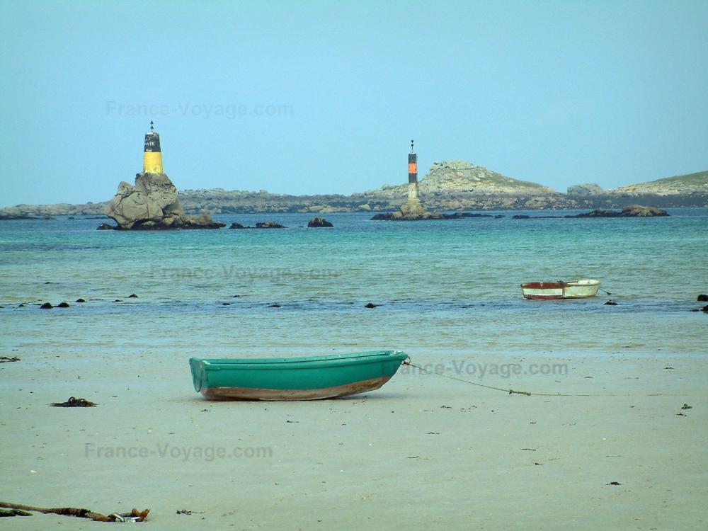 Guide du Finistère - Paysages du littoral de Bretagne - Plage de sable avec une petite barque colorée, mer, phares, et côtes au loin