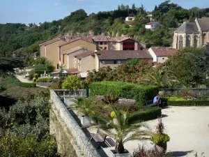 Fumel - Terrasse du château, agrémentée de palmiers et de fleurs, avec vue sur le chevet de l'église Saint-Antoine et les maisons de la ville 