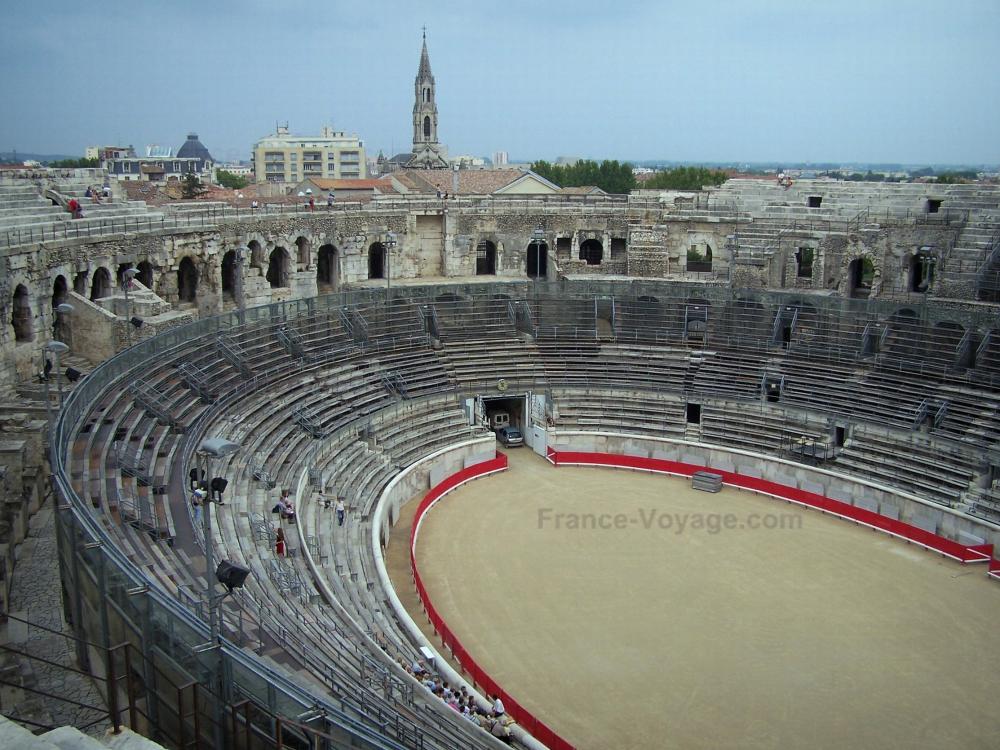 Guide du Gard - Nîmes - Arènes (amphithéâtre romain) et clocher de l'église Sainte-Perpétue et Sainte-Félicité en arrière-plan