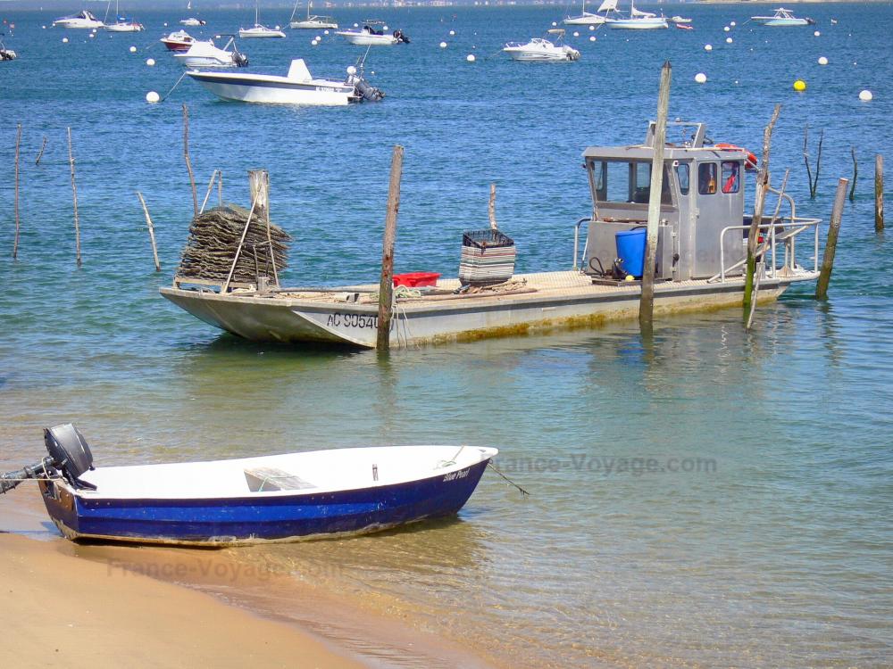Guide de la Gironde - Paysages de la Gironde - Bassin d'Arcachon : bateaux sur l'eau, dont un bateau ostréicole