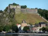 Givet - Forte di vittoria torre Charlemont dominante e case della città dal fiume Mosa nel Parc Naturel Régional des Ardennes