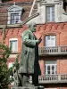 Godin gemeensschapshuis - Standbeeld van Jean-Baptiste Andre Godin, de maker van Familistery van Guise, en bakstenen gevel van de linkervleugel van Familistery (sociale paleis) in Thierache