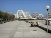 La Grande-Motte - Promenade agrémentée de bancs et de lampadaires, immeubles en forme de pyramide de la station balnéaire