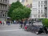 Grenoble - Line of bikes, trees, tram, shops and facades of the town