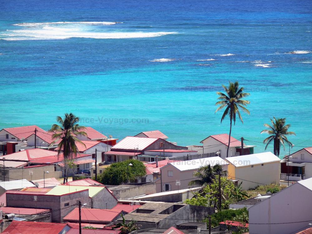 Guide de Guadeloupe - Marie-Galante - Vue sur les toits de maisons du bourg de Capesterre-de-Marie-Galante et la mer des Caraïbes aux eaux turquoises