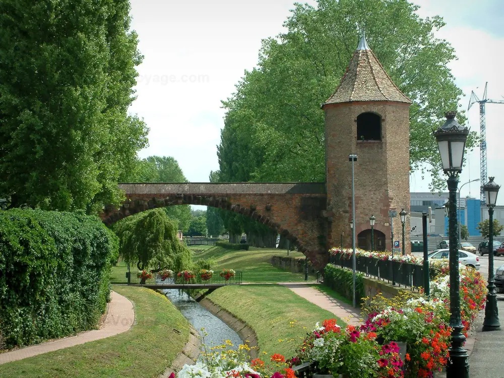 Haguenau - Berge fleurie, lampadaires, tour des Pêcheurs avec une arche, rivière et arbres