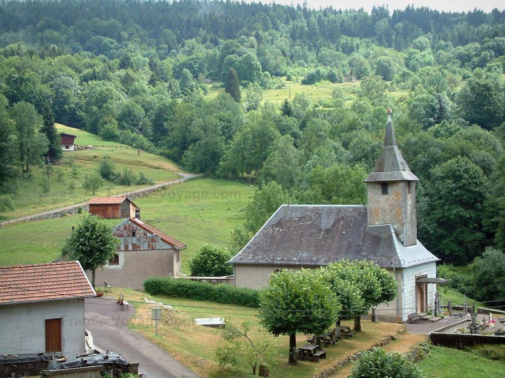 Guide de la Haute-Saône - Vosges Saônoises - Église et chalets d'un village, arbres d'une forêt (Parc Naturel Régional des Ballons des Vosges)