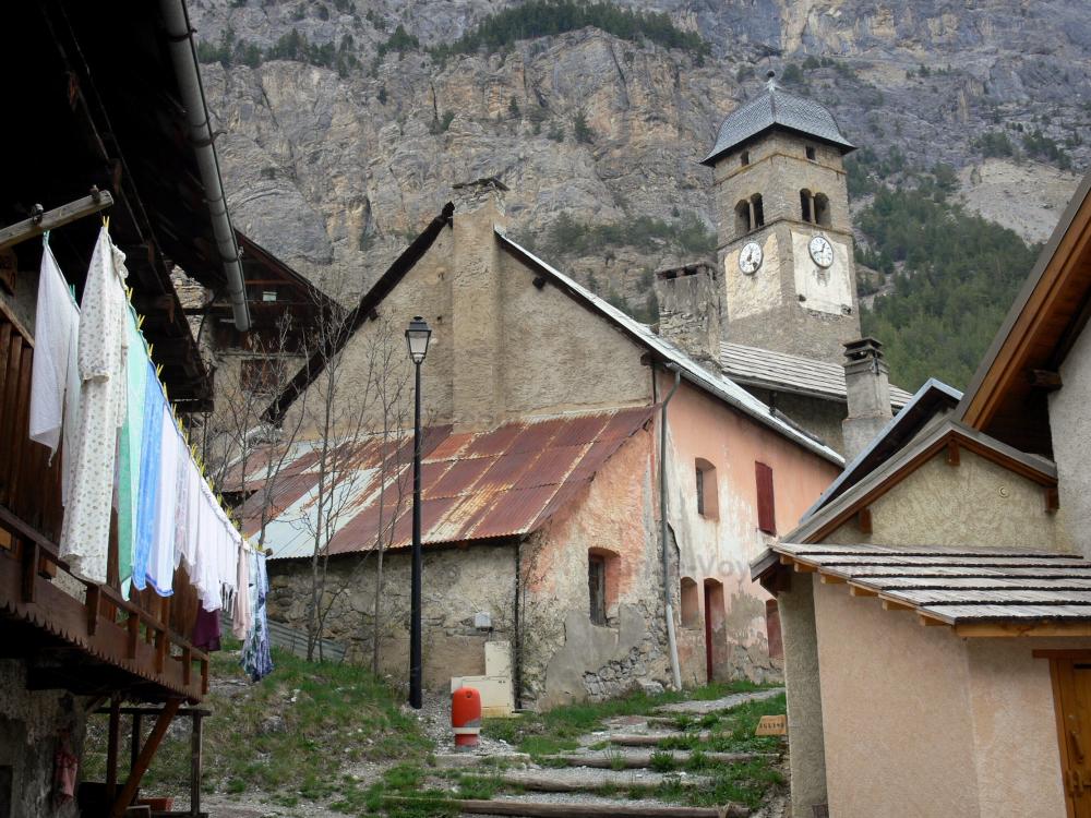 Guide des Hautes-Alpes - Plampinet - Clocher de l'église Saint-Sébastien et maisons du village ; dans la vallée de la Clarée