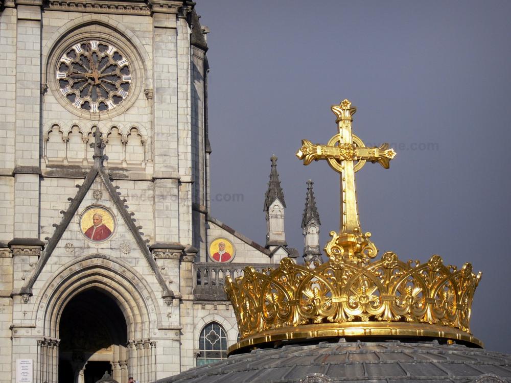 Guide des Hautes-Pyrénées - Lourdes - Domaine de la Grotte (sanctuaires, cité religieuse) : coupole de la basilique Notre-Dame du Rosaire surmontée d'une couronne et d'une croix dorée ; basilique de l'Immaculée Conception (basilique supérieure) de style néogothique en arrière-plan